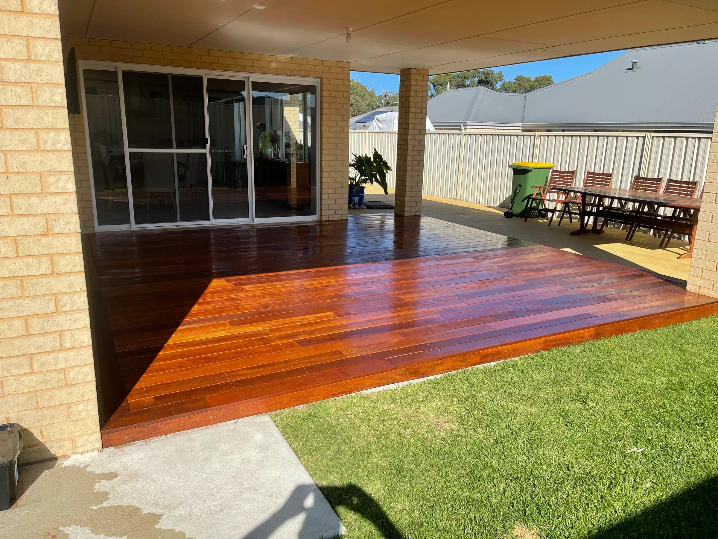 Oiled jarrah alfresco deck meeting a lawn at the rear of a house