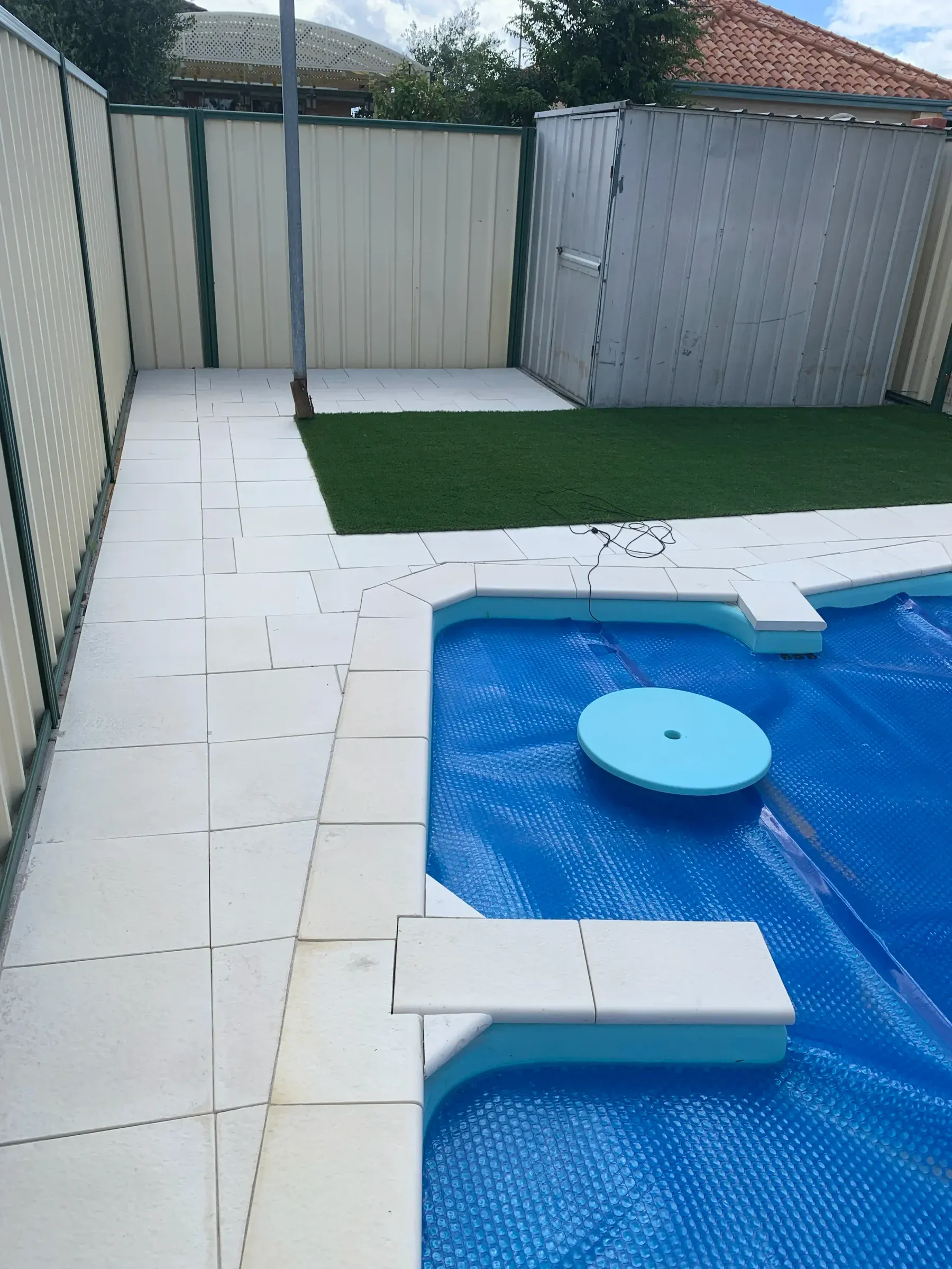 Pool surround part paved, with the remaining lawn area still to be lifted