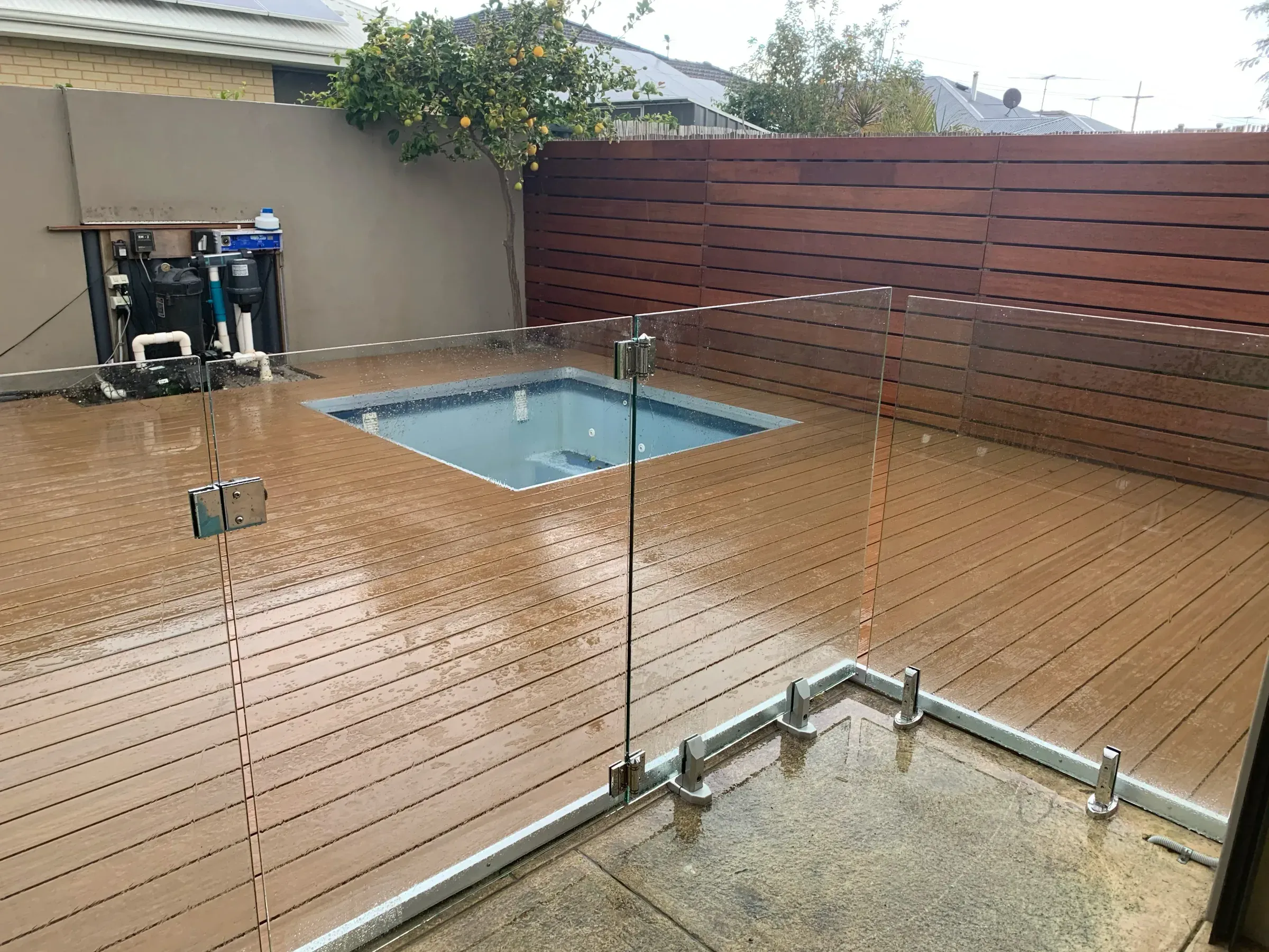 Corner detail of a frameless glass pool fence with spigot fixings into the deck